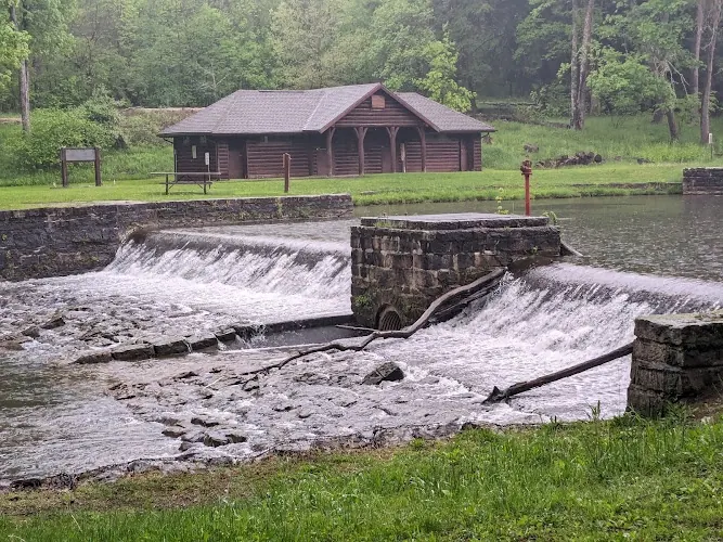 Loleta's log bathhouse beyond the historic stone mill-pond dam and spillway
