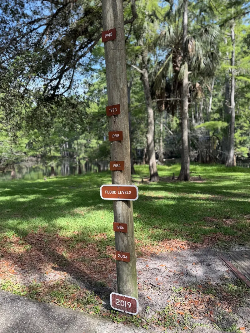 Historical flood-level marker beside a path at Manatee Springs State Park