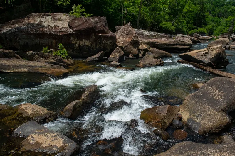 Whitewater flowing between large boulders in the Meadow River collection; regional scenery, not a verified Bubbie Hole swimming entrance