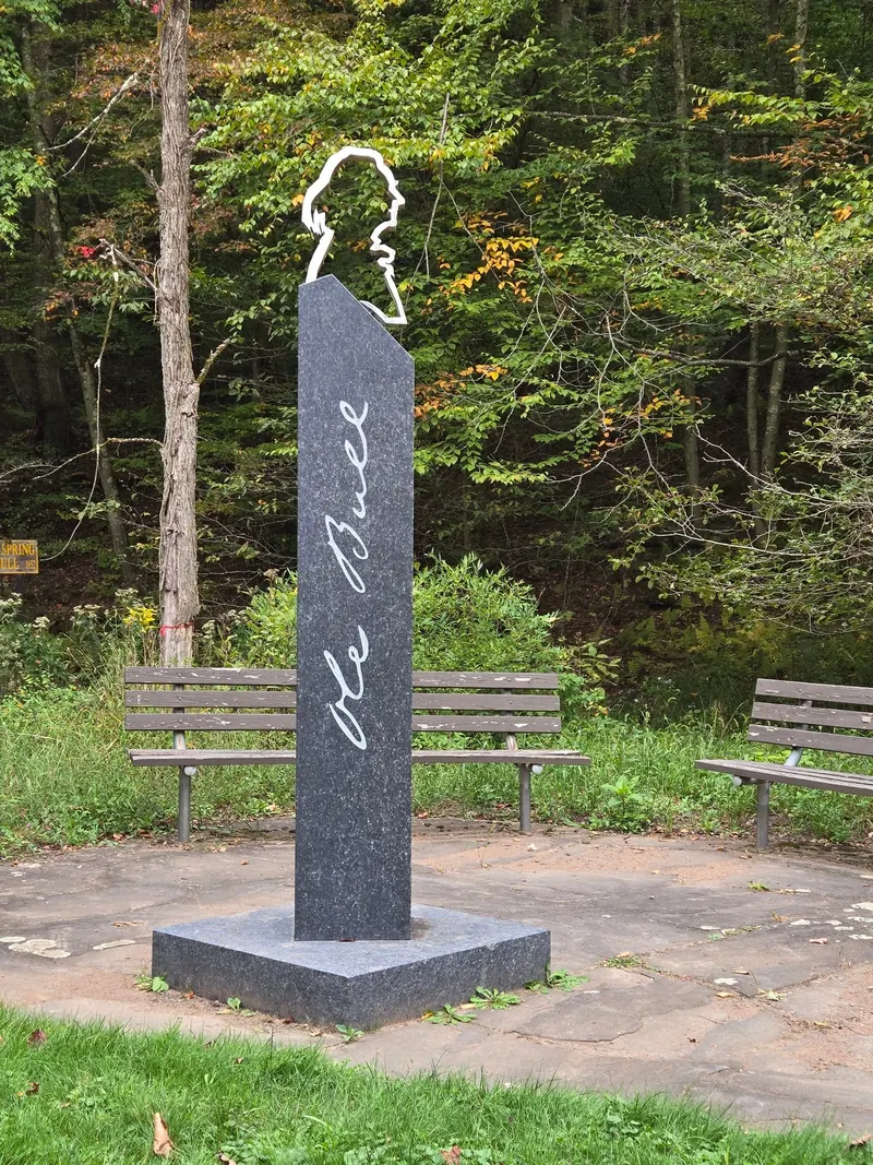 Ole Bull memorial beside benches and woodland