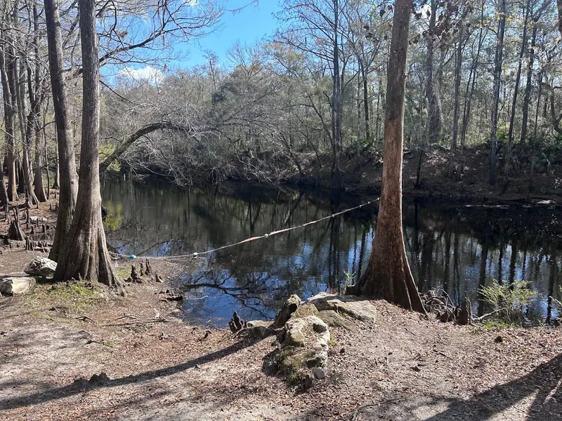 Historical floating boundary rope across a wooded Santa Fe River pool at O'Leno; not confirmation of current swimming permission