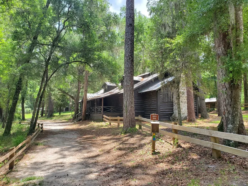 Historical wooden park building and River Trail marker at O'Leno State Park; not lodging or proof of an accessible water-entry route