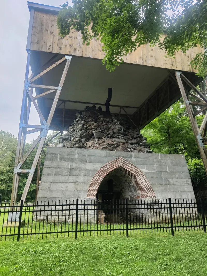 Protected stone and brick furnace remains at Copake Iron Works beneath a shelter
