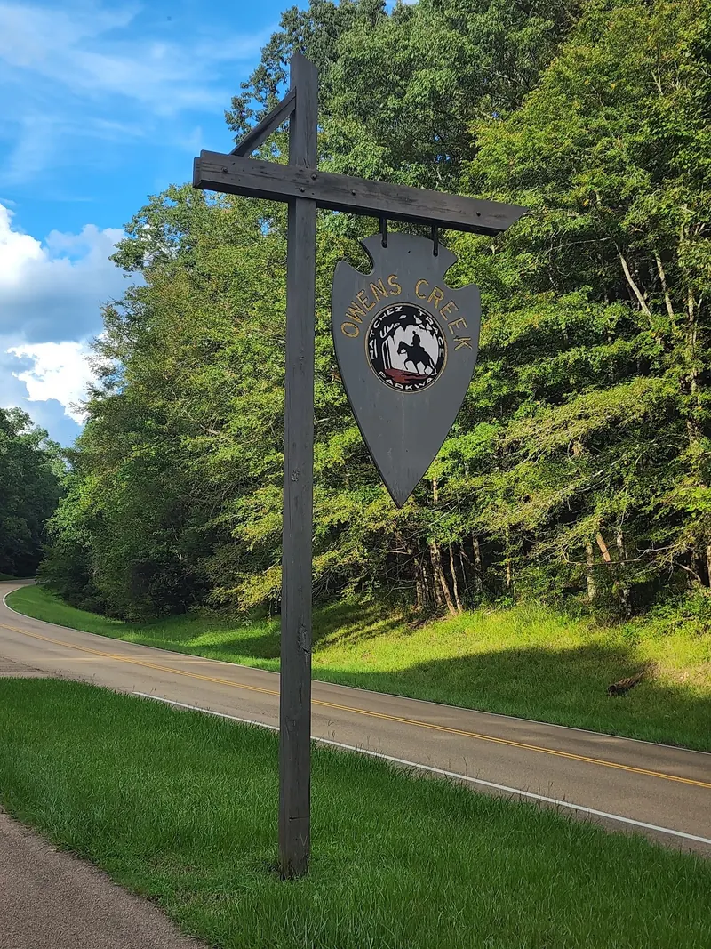 Owens Creek Natchez Trace Parkway stop sign beside the wooded roadway