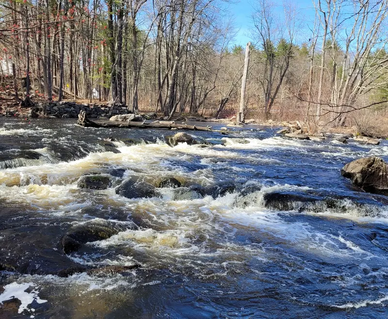 Fast-moving Lamprey River water over rocky ledges at Packers Falls
