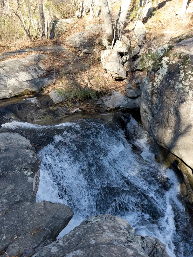 Water dropping between steep rock shelves in the Panther Falls area, not a recommended water-entry route