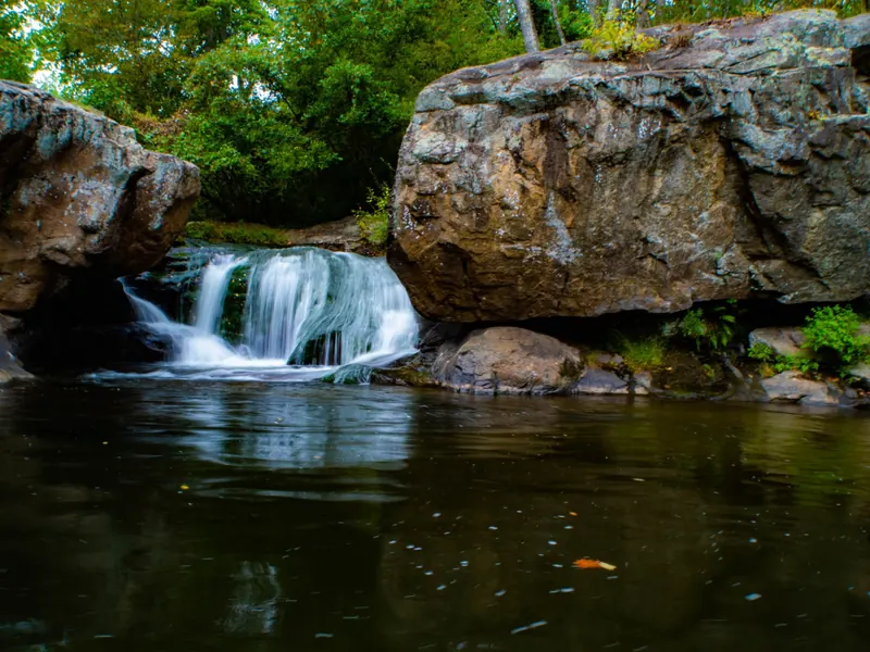 Panther Falls cascading between large rock shelves into a dark pool on the Pedlar River