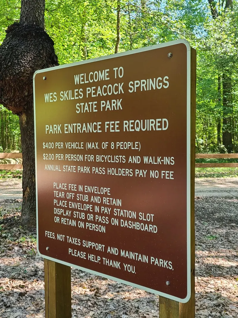 Historical Peacock Springs entrance-fee sign explaining the envelope pay station; photographed prices are not a current fee confirmation