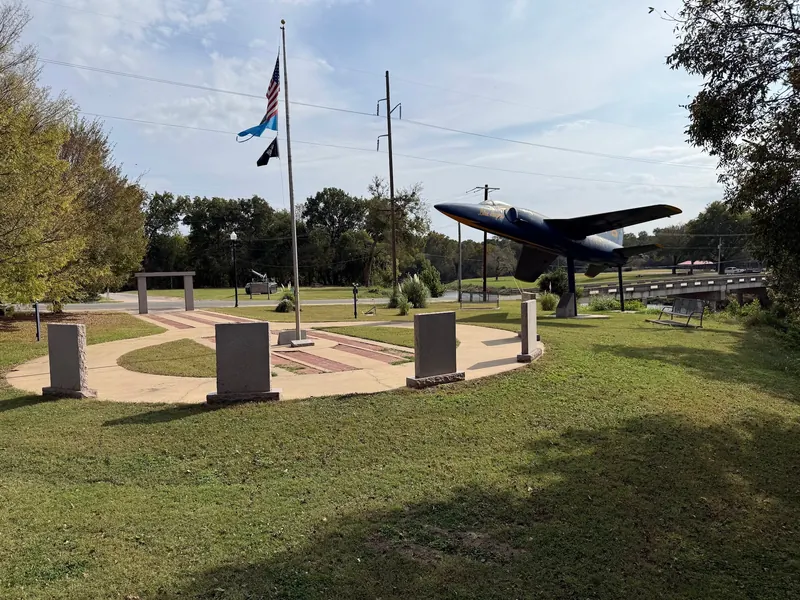 Memorial-area paths and aircraft display beside the Pennington Creek bridge