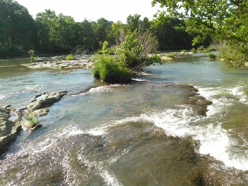 Pennington Creek flowing across rock shelves between wooded banks