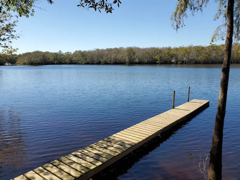 Wooden dock extending into tree-bordered lake water at Presley's Outing, not a diving invitation