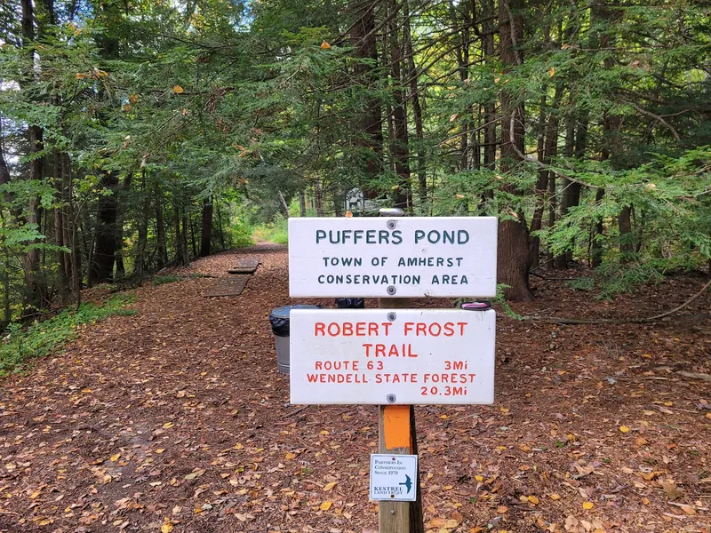 Puffer's Pond town conservation-area sign beside the Robert Frost Trail sign