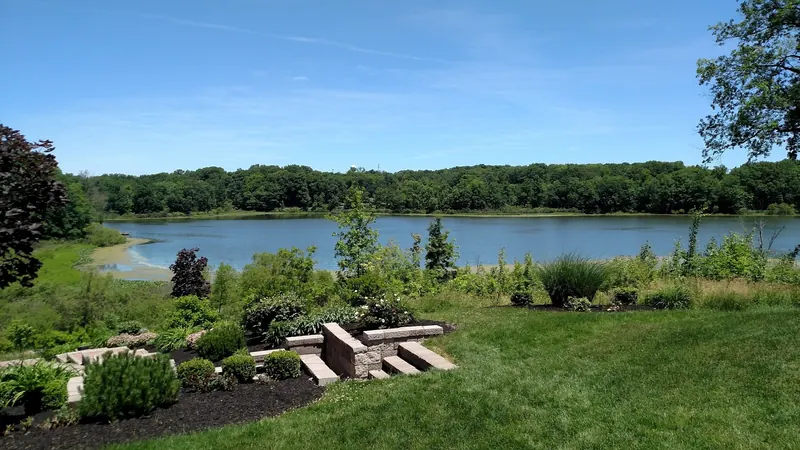Landscaped lawn and stone seating overlooking Punderson Lake, separate from the swimming beach