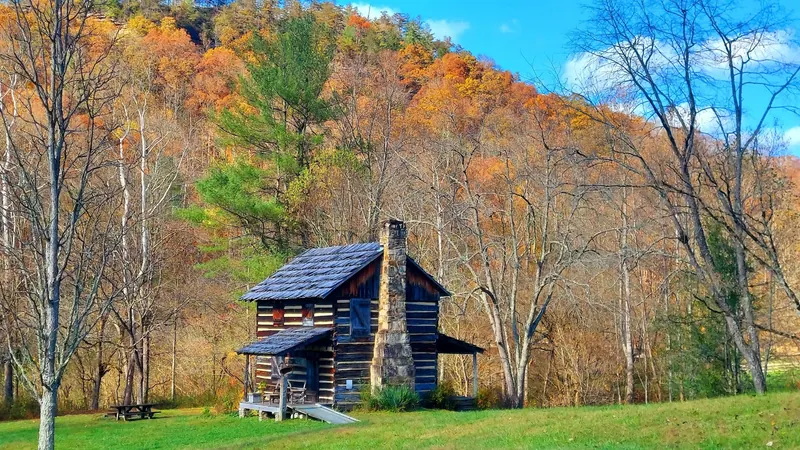 Historic log cabin beneath autumn trees in the saved Red River Gorge area collection, not swimming facilities
