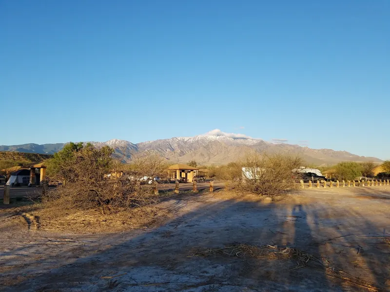 Shaded campsites and RVs below a mountain ridge at Roper Lake State Park