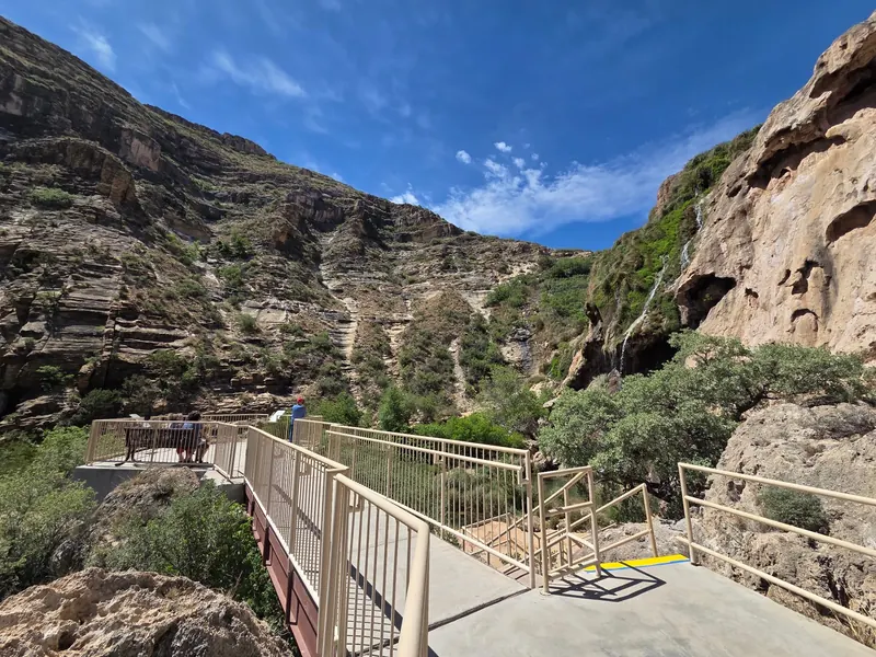 Railed viewing platform and steps facing the rocky canyon at Sitting Bull Falls