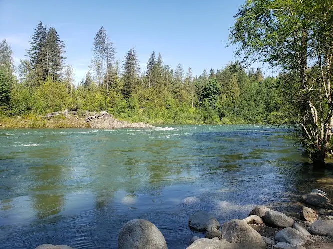 Skykomish River flowing past a rocky shoreline and forest at Big Eddy Public Water Access near Gold Bar
