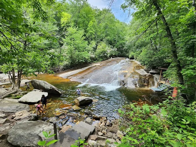 Sliding Rock cascade and pool surrounded by green forest, with a viewing platform on the right