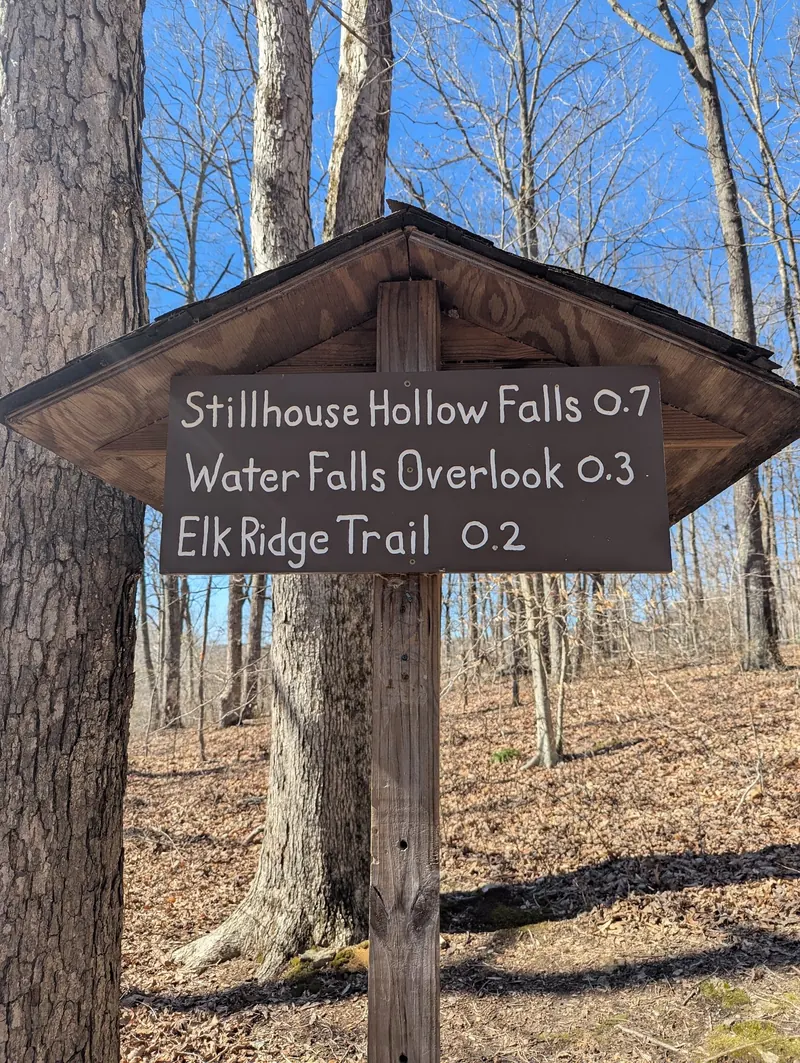 Trail sign listing Stillhouse Hollow Falls at 0.7, the waterfall overlook at 0.3 and Elk Ridge Trail at 0.2