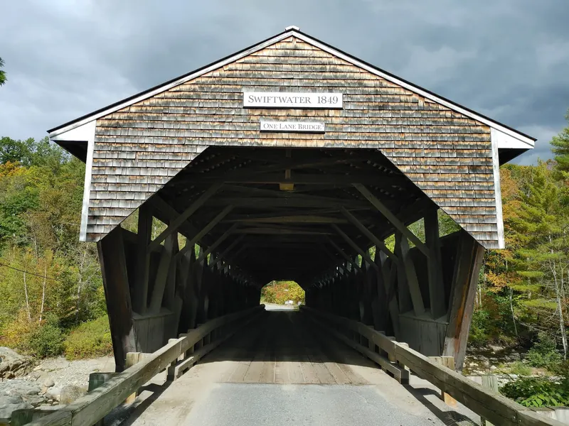 Shingled entrance to Swiftwater Covered Bridge with its name and 1849 date