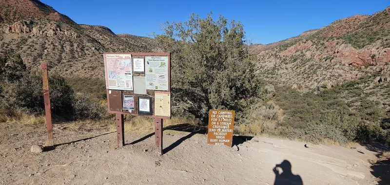 Parsons Trailhead information board and lower-valley camping restriction sign; historical signage