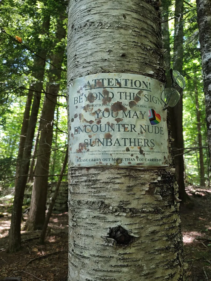 Historical Friends of The Ledges sign warning of a traditional clothing-optional area beyond this point