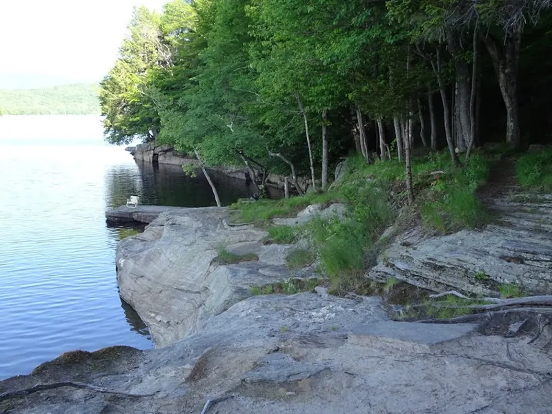 Empty rock shelves beside water and wooded banks in The Ledges Harriman Reservoir collection