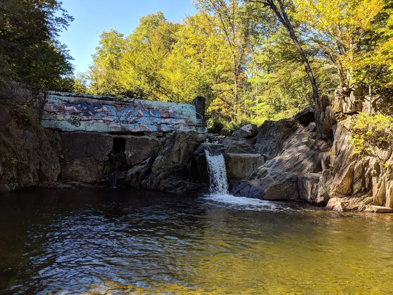Historical dam remnants and brook pool in The Mill collection on Minister Brook; scenery, not a safe jumping platform or verified current water-entry route
