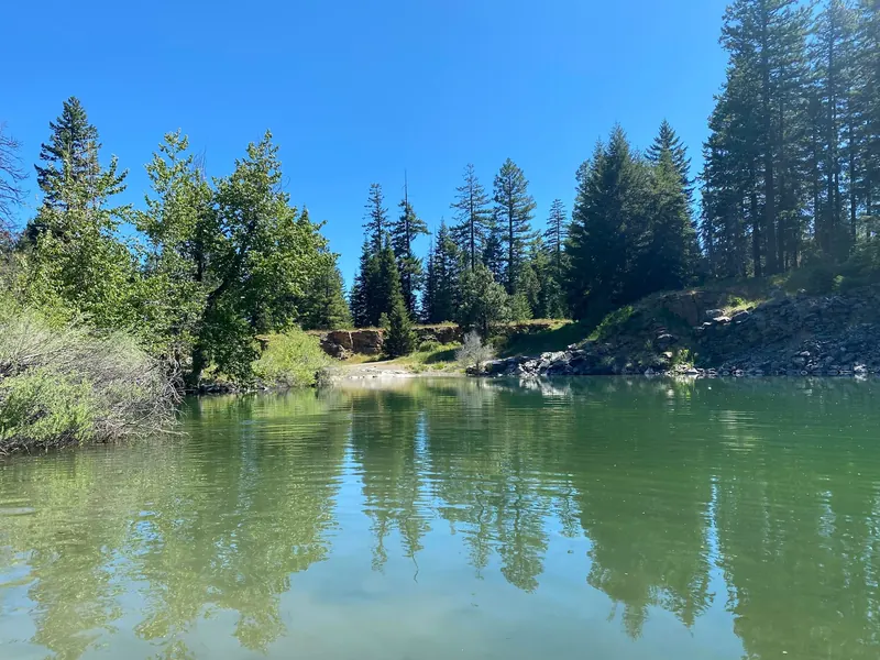 Green quarry pond beneath wooded banks and exposed rock in a historical Rock Quarry photo near Ashland