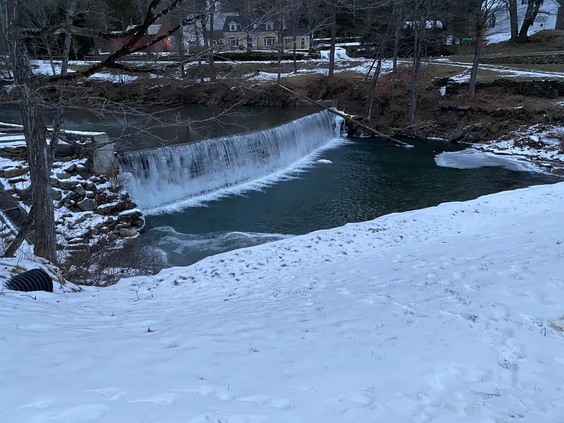 Snow-covered banks and ice beside flowing water at the Green River timber crib dam