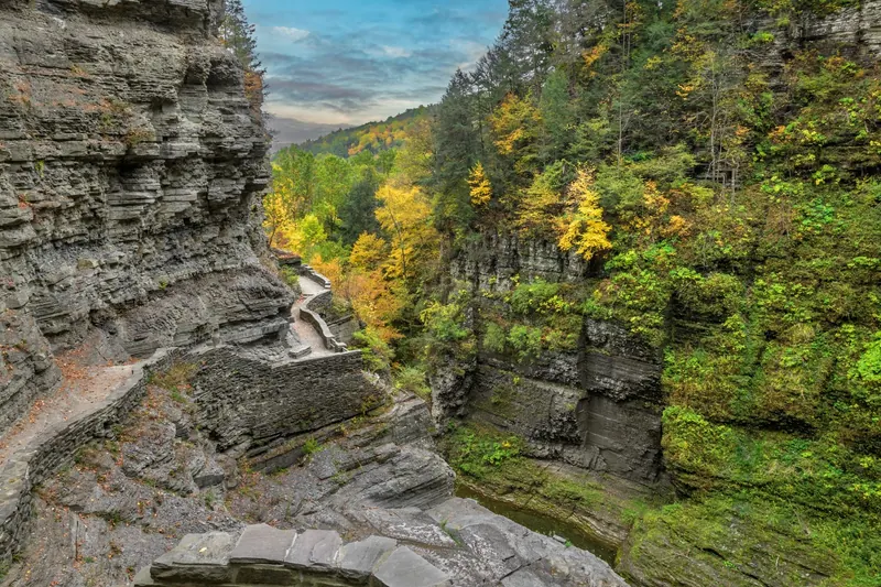 Stone steps and a walled hiking path above the gorge at Robert H. Treman State Park