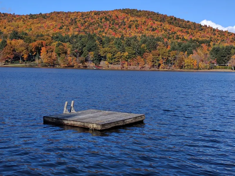 Autumn hillside across Trout Lake with a floating platform whose public access is unverified