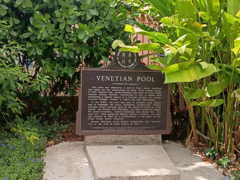 Venetian Pool historical marker surrounded by tropical foliage; landmark context