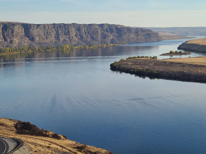 Wide view of Wanapum Lake with cliffs, shoreline trees and dry hills; general reservoir scenery, not an identified swim beach
