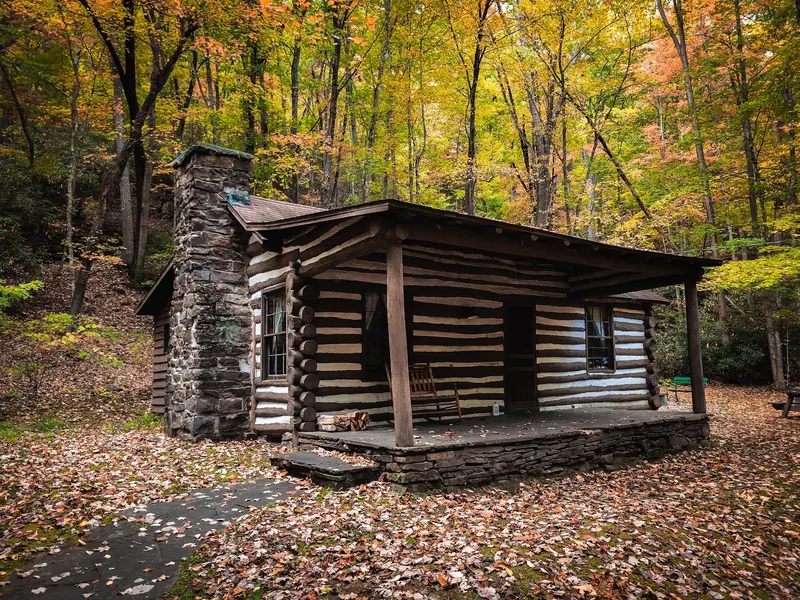 Log cabin among autumn trees at Watoga State Park, not the Riverside Campground swimming location