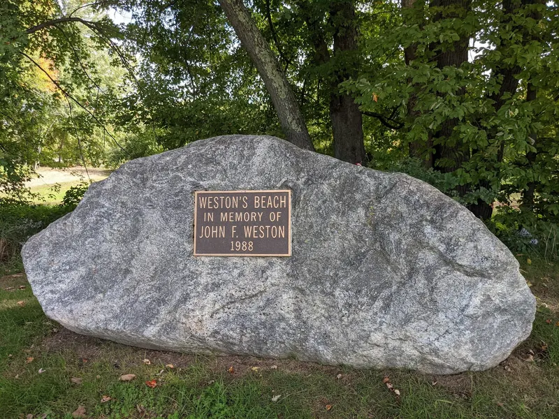 Weston's Beach memorial plaque commemorating John F. Weston on a granite boulder among trees