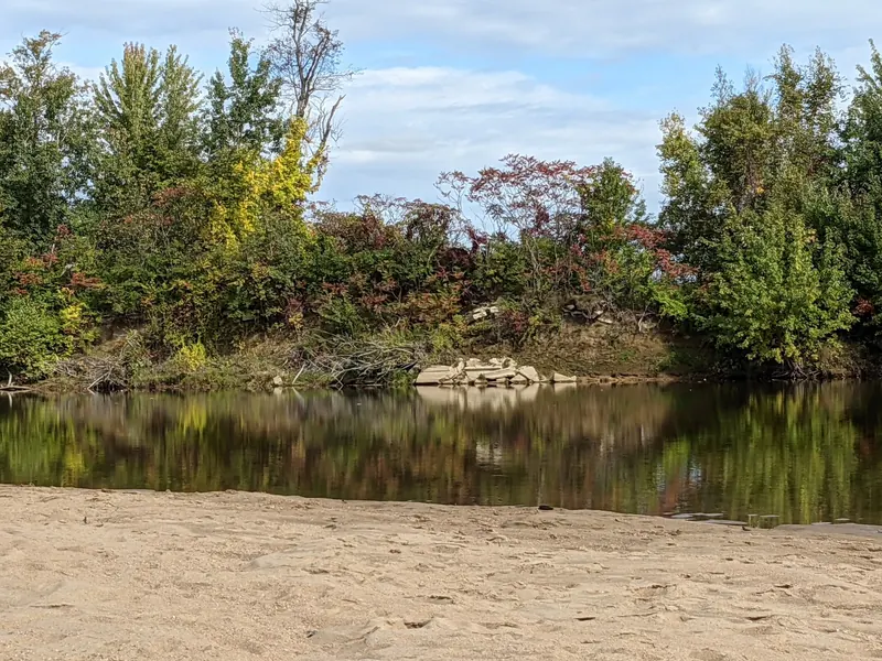 Quiet historical Saco River bank in the saved Weston's Beach collection with trees reflected in the water